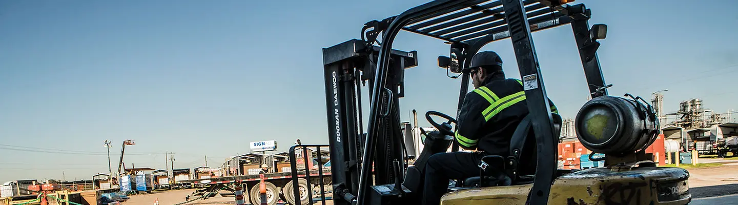 Worker using a forklift at job site