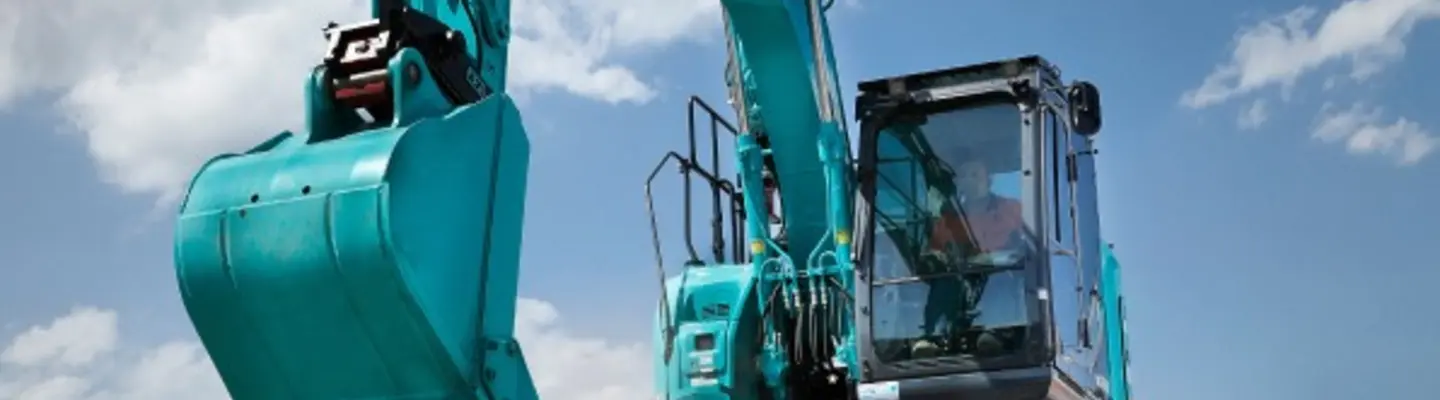 A man operating heavy equipment to dig and move sand at a construction site, focusing on earthmoving tasks.