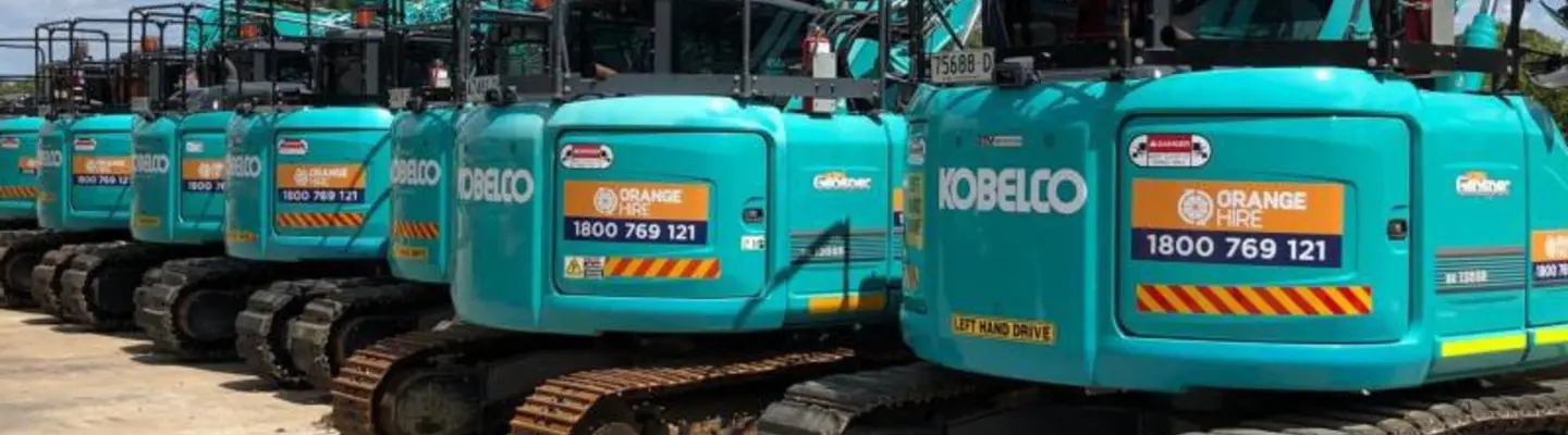 Multiple excavators lined up at a construction site, representing Orange Hire’s fleet for earthmoving and barrier projects.