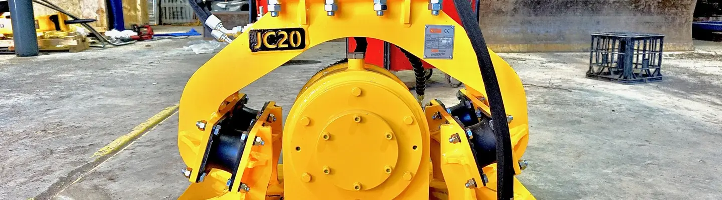 Plate compactor machine on a construction site near safety barriers, used for compacting soil and maintaining ground stability.