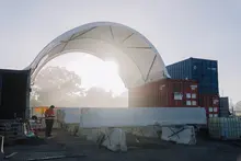 Man adjusting various safety barriers with portable equipment at a construction site, emphasizing workplace safety setup.