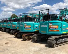 Multiple excavators displayed at a construction site, showcasing equipment used for digging and barrier installation work.